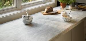 Concrete countertop with bowls, bread, and plant.